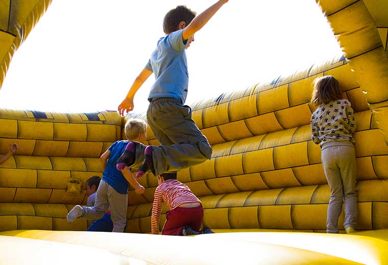 kids having fun playing on an inflatable moon bounce bounce house